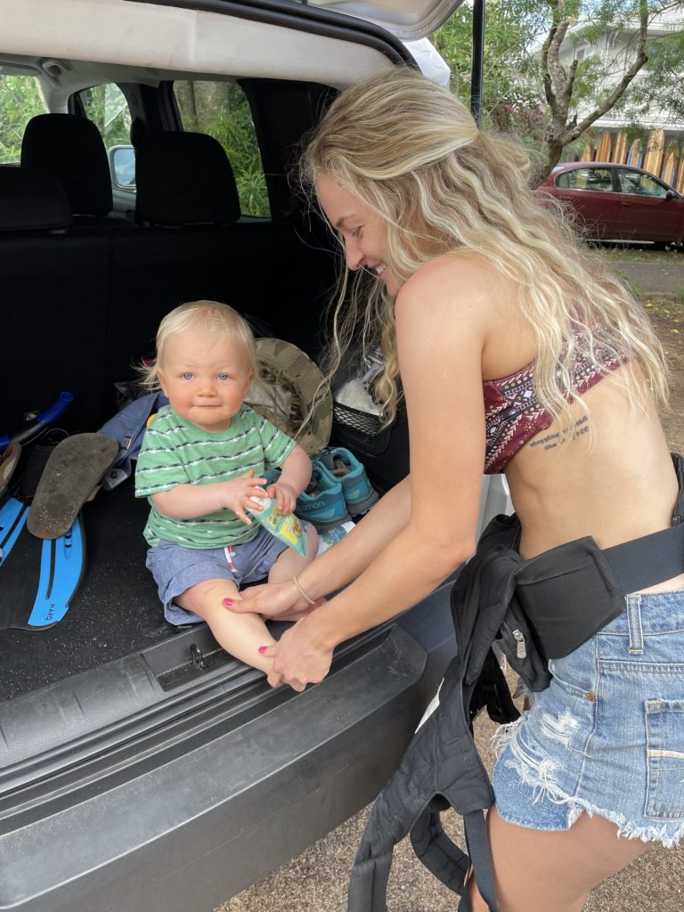 Mom putting sunscreen on toddler before going to the beach