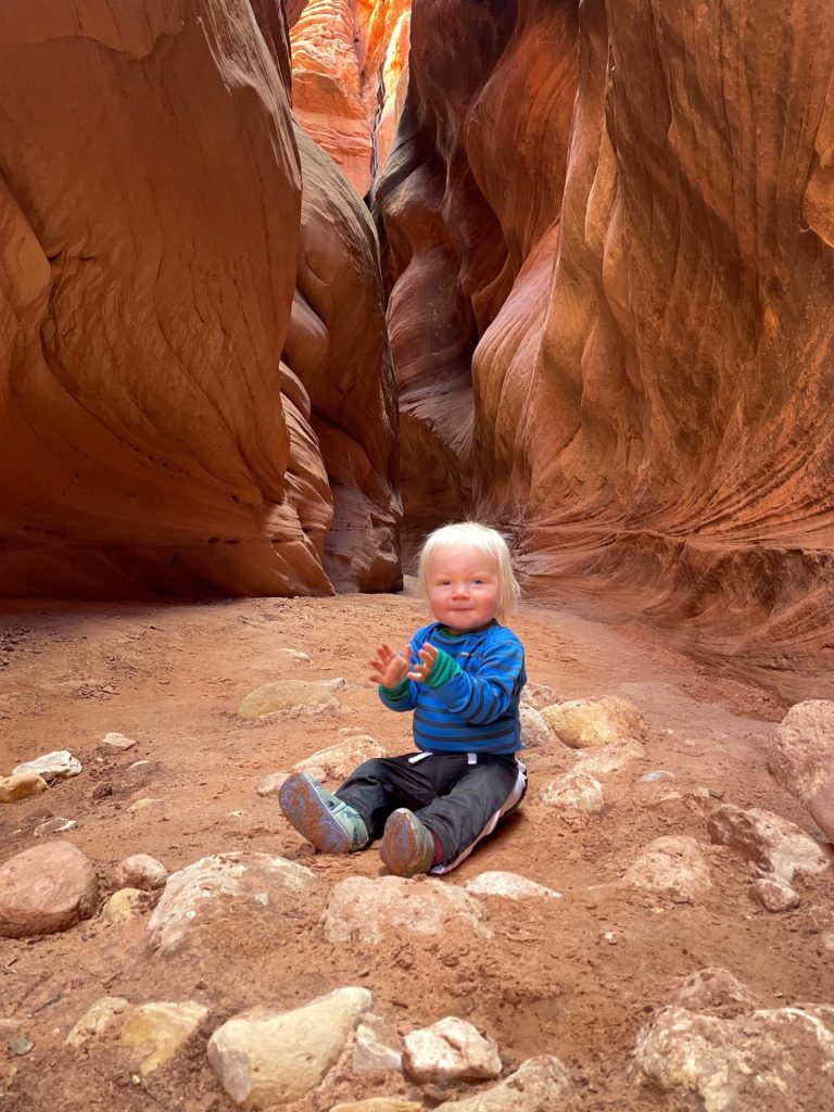 hailey's toddler sitting in front of a slot canyon