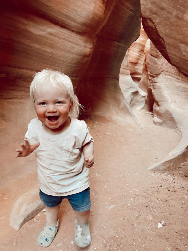 Hailey's toddler smiling as he walks through the slot canyons