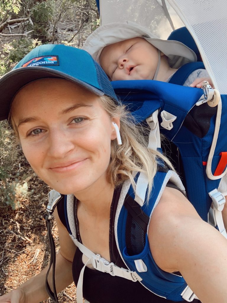 Hailey smiling while her baby sleeps in the Osprey carrier on her back