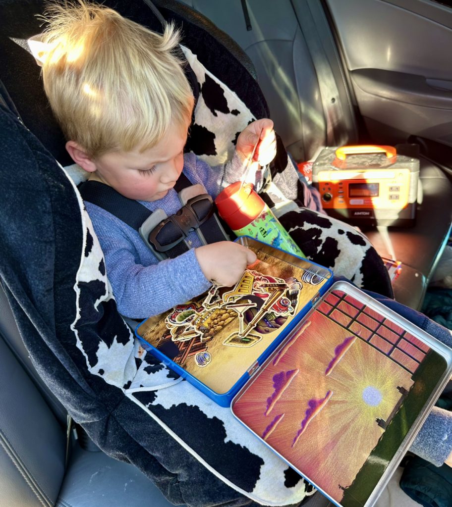toddler playing in carseat on a road trip