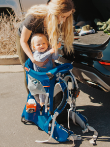 Hailey loading up her toddler in the framed hiking child carrier