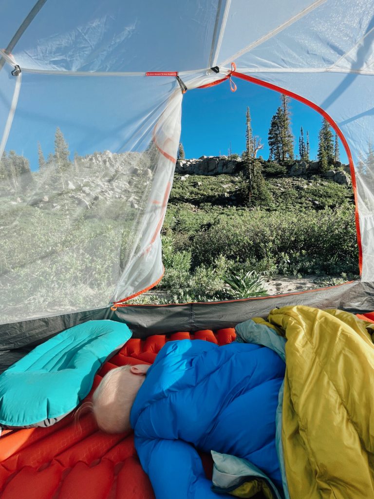 Baby sleeping with view outside of tent