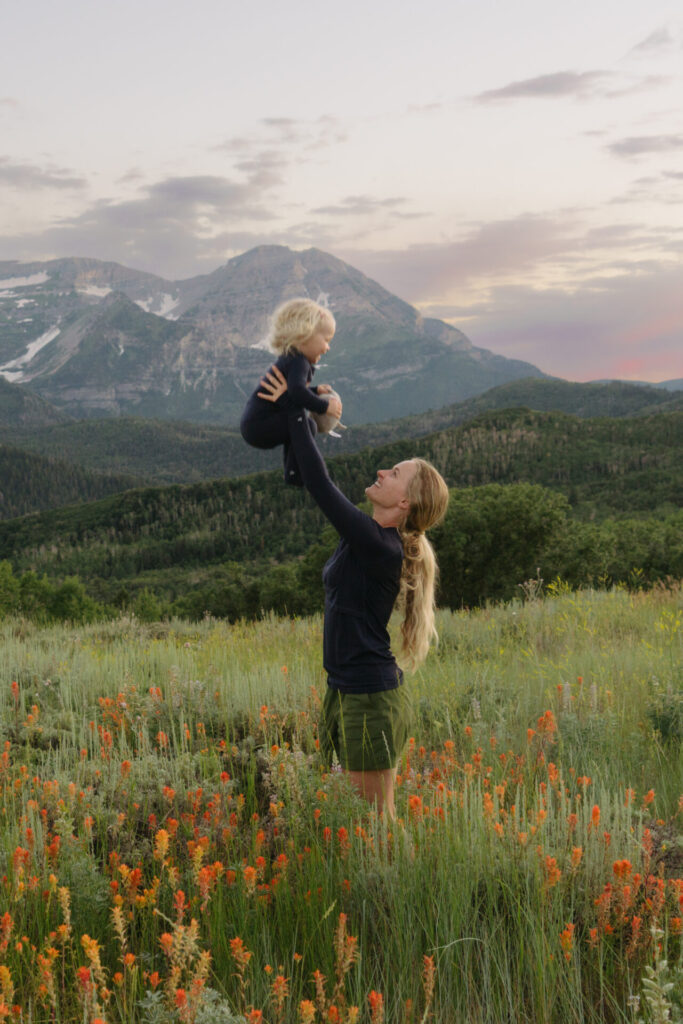 Mother and daughter in field of wildflowers, both in merino wool base layers
